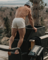 Man outside, going into a cold plunge bucket in a NADS White Organic Cotton Boxer. 