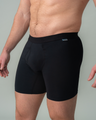 Person wearing black swim shorts on a plain background