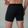 Person wearing black boxer briefs against a plain background